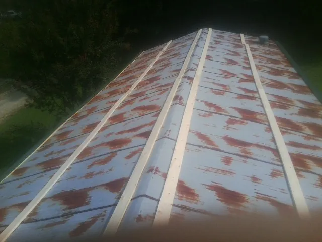 Rusted metal roof panels with new wood purlins before replacement — Storm Damage Roof Repair in Plumerville by Roofing Brothers