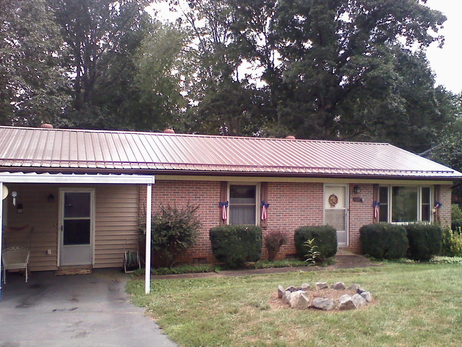 Bronze metal roof and carport on a brick ranch home — Roof Repair work by our crew in Plumerville